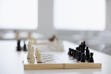 Chess pieces poised for a strategic battle in a bright, modern room