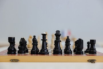 Black chess pieces poised for an intense battle on a wooden board