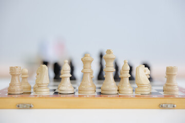 Chess pieces poised for a strategic showdown on a wooden board in a calm setting