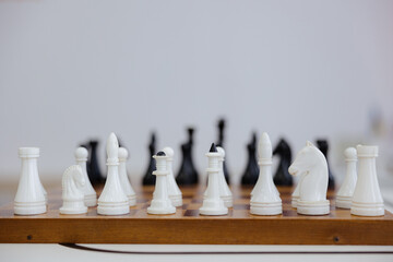 Chess pieces poised for a strategic battle on a timeless board in a serene setting