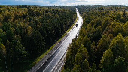 Obraz premium a truck driving on the highway at sunset, drone view