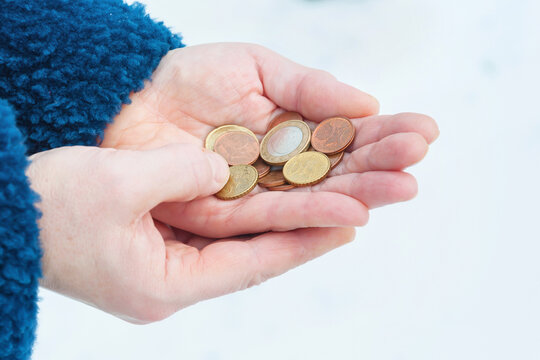 Euro coins in a woman's hands, selective focus.	