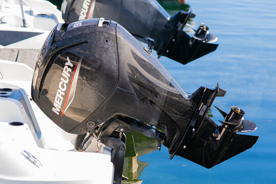 Weathered 90 hp Mercury Outboards on white rental boats sunny day summer Okanagan lake