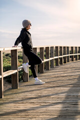 sporty woman resting on a wooden boardwalk after exercise
