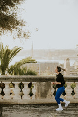 Woman jogging by the coast in Malta while enjoying the view during the day