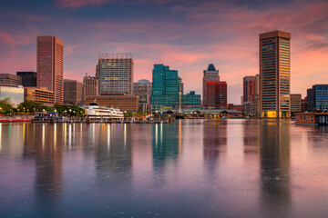 Baltimore, Maryland, USA. Cityscape image of downtown Baltimore, Maryland with reflection of the skyline in the water at beautiful autumn sunrise