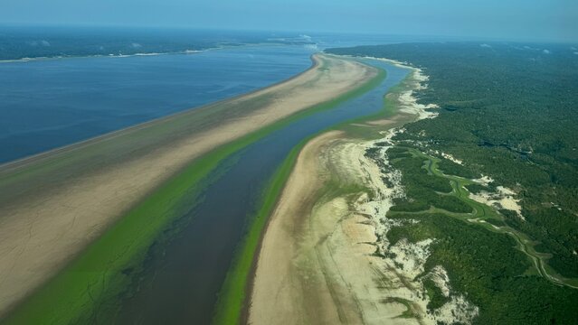 Aerial view of the Amazon River basin affected by historic drought in 2024, showing extremely low water levels along the Rio Negro in the state of Amazonas, Brazil. Exposed riverbanks and reduced wate