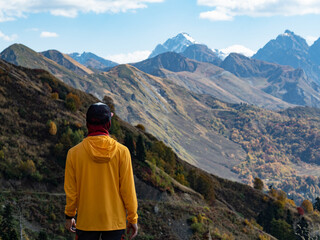 A father with backpack carrier and his child are hiking in mountains and looking at sunset. Not AI