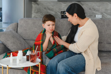 Mother comforting sick boy suffering from sore throat