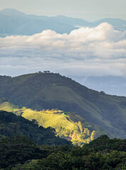 View west from Monteverde resort at sunrise over the hills towards Pacific ocean in vertical format