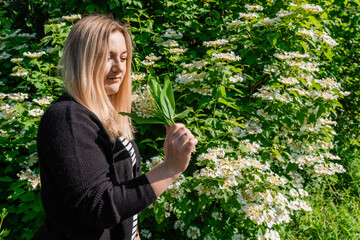 Young woman holding beautiful bouquet of a lillies of a valley flowers.