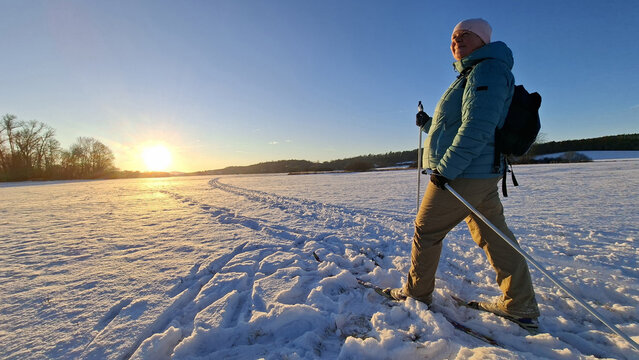 Mature woman skiing on trail in winter cold weather. Cross-country skier in snowy National park Sumava, Czech Republic.
