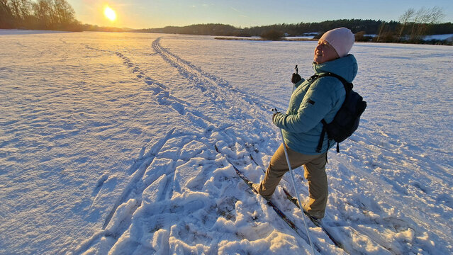 Mature woman skiing on trail in winter cold weather. Cross-country skier in snowy National park Sumava, Czech Republic.