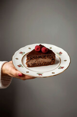 Woman holding a slice of chocolate cake