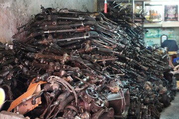 Massive stack of used car steering racks in automotive parts warehouse