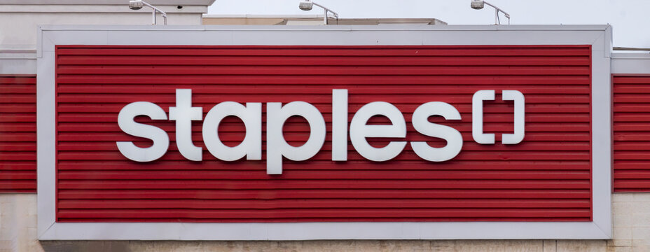Calgary, Alberta, Canada. January 14, 2026. The corporate logo of a Staples retail store on a red corrugated metal building exterior.