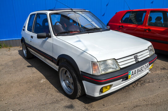 Striking white Peugeot 205 GTI legendary three door French car is celebrated for its agile handling and pure driving dynamics, epitomizing the 1980s hot hatch era