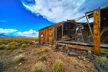 Fototapeta premium Abandoned Desert House Weathered Wood and Dramatic Sky in California Landscape