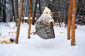 Swing surrounded by snowy trees in a winter wonderland park