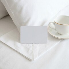 Blank White Card on Crisp Bedding with Coffee Cup Minimalist Hotel Room Scene.