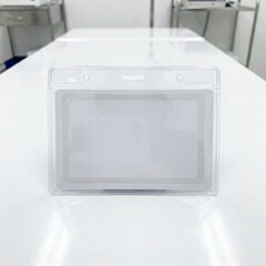 Clear Plastic ID Badge Holder on White Table.