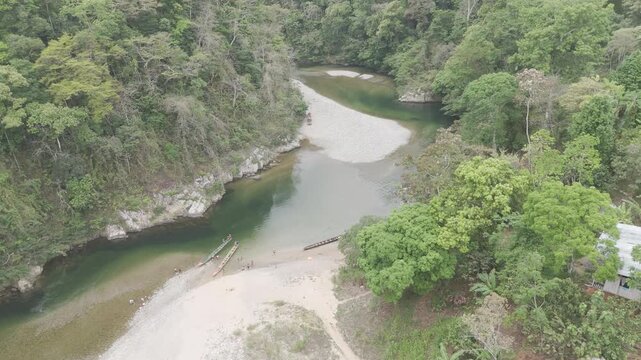 Aerial drone view of Embera Drua indigenous village located along the Chagres River in Colon, Panama. This cinematic scene showcases traditional huts, river landscape, and surrounding tropical rainfor
