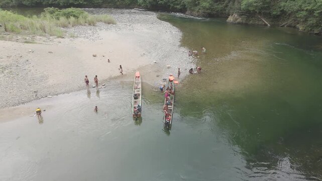 Aerial drone view of Embera Drua indigenous village located along the Chagres River in Colon, Panama. This cinematic scene showcases traditional huts, river landscape, and surrounding tropical rainfor