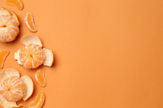 Fresh tangerines on orange background, flat lay. Space for text