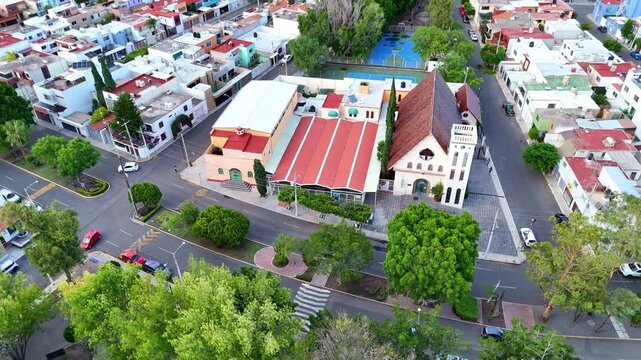 Church "Parroquia Sagrada Familia" in Queretaro, located among parks in an urban area aerial view