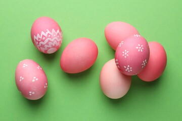 Beautiful decorated Easter eggs on green background, flat lay