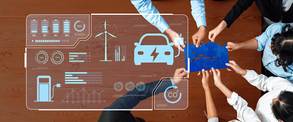 A group of diverse individuals collaborates over a table, assembling puzzle pieces with electric vehicle graphics and data displays, emphasizing teamwork in sustainable technology. Trope