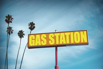 Old worn gas station sign with palm trees