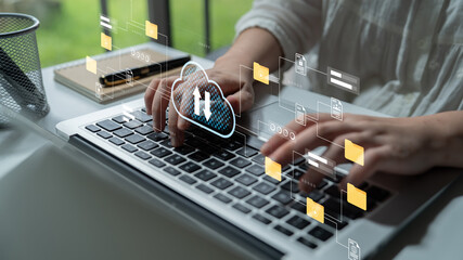 A person types on a laptop with cloud computing graphics overlay, illustrating technology integration in a modern workspace and the impact of digital tools on productivity. Gantry