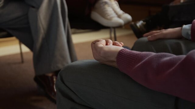 Close up on unrecognizable restless teenage boy tapping foot nervously and twitching fingers during group therapy at college counseling room