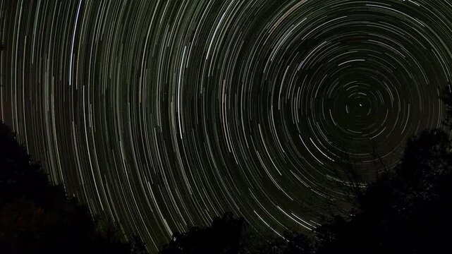 Long exposure video of star trails forming concentric arcs on a dark sky, capturing Earth&rsquo;s rotation with stars creating circular light paths of varying brightness, 2026