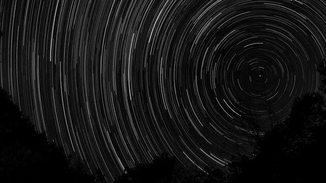 Long exposure video of star trails forming concentric arcs on a dark sky, capturing Earth&rsquo;s rotation with stars creating circular light paths of varying brightness, 2026