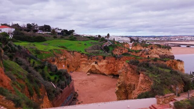 Revealing shot of Ponte do Antigo Forte do Pinhao at Praia dos Estudantes in Lagos Algarve Portugal. 