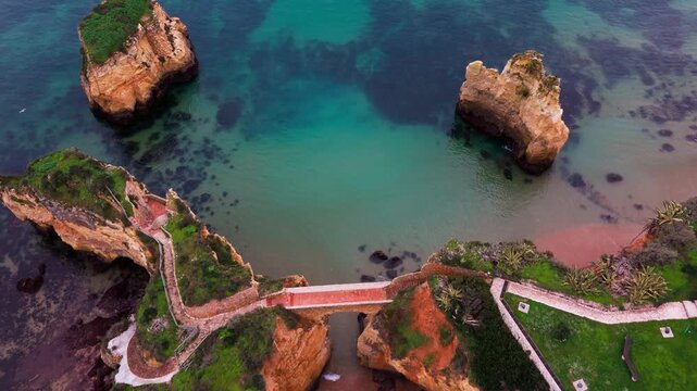 Top-down aerial view of Ponte do Antigo Forte do Pinhao at Praia dos Estudantes in Lagos Algarve Portugal. 