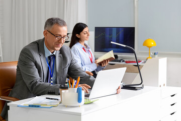 Male business analyst working with laptop at desk in office. Data science concept