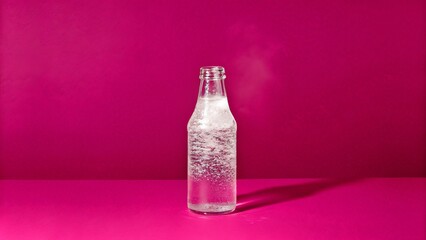 Transparent Glass Bottle Filled with Effervescent Drink on Pink Surface
