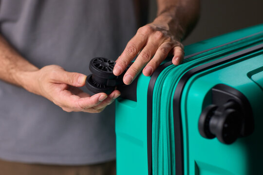 Inspecting suitcase wheels for strength and smooth operation before travel, Traveler thoroughly assesses condition and reliability of suitcase wheels for upcoming journey