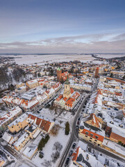 Obraz premium Drone aerial of Byczyna in winter, Poland. White-covered old town, medieval layout and peaceful snowy landscape.