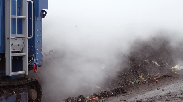 An industrial conveyor system aerator recycles organic waste using steam rising inside the waste processing plant. Processing of organic waste