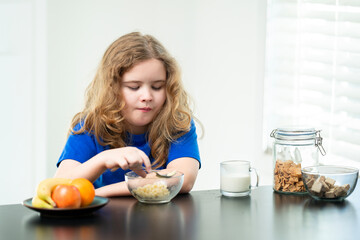Natural food at home. Happy childhood breakfast moment. Child with spoon and cereal. Healthy food for child. Smiling face at breakfast. Kid eating cereal with milk. Morning breakfast in kitchen.