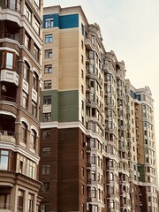 Fototapeta premium Elegant Urban Building Exterior, Modern City Residence With Decorative Features, Sophisticated City Apartment Complex Showcasing Ornate Brickwork And Scenic Cityscape Backdrop
