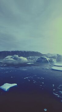 frozen sea with scattered ice chunks and twilight reflections, cool blue palette, gentle ripples around berg fragments, quiet maritime atmosphere for climate