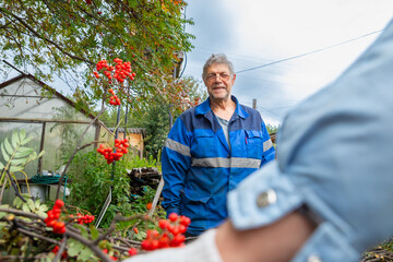 two farm workers talking. Senior man worker on organic farm. Portrait of male person in work...