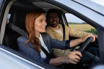 Cheerful woman driving a car with partner