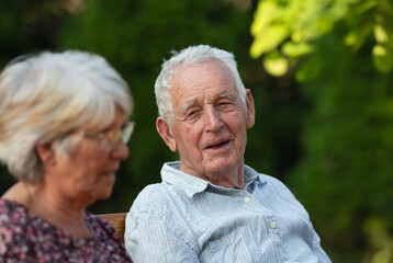 Old man and woman talking happily outside