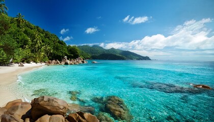 Obraz premium Serene Coastal Cove Tropical Beach Rocks Lush Green Mountains Clear Water